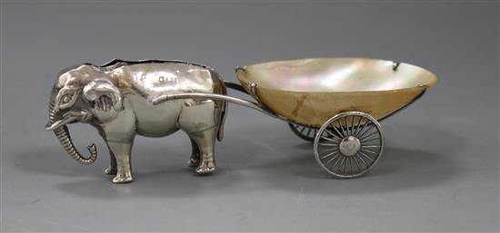 An early 20th century novelty pin cushion modelled as an elephant pulling a mother of pearl cart, 12.2cm.